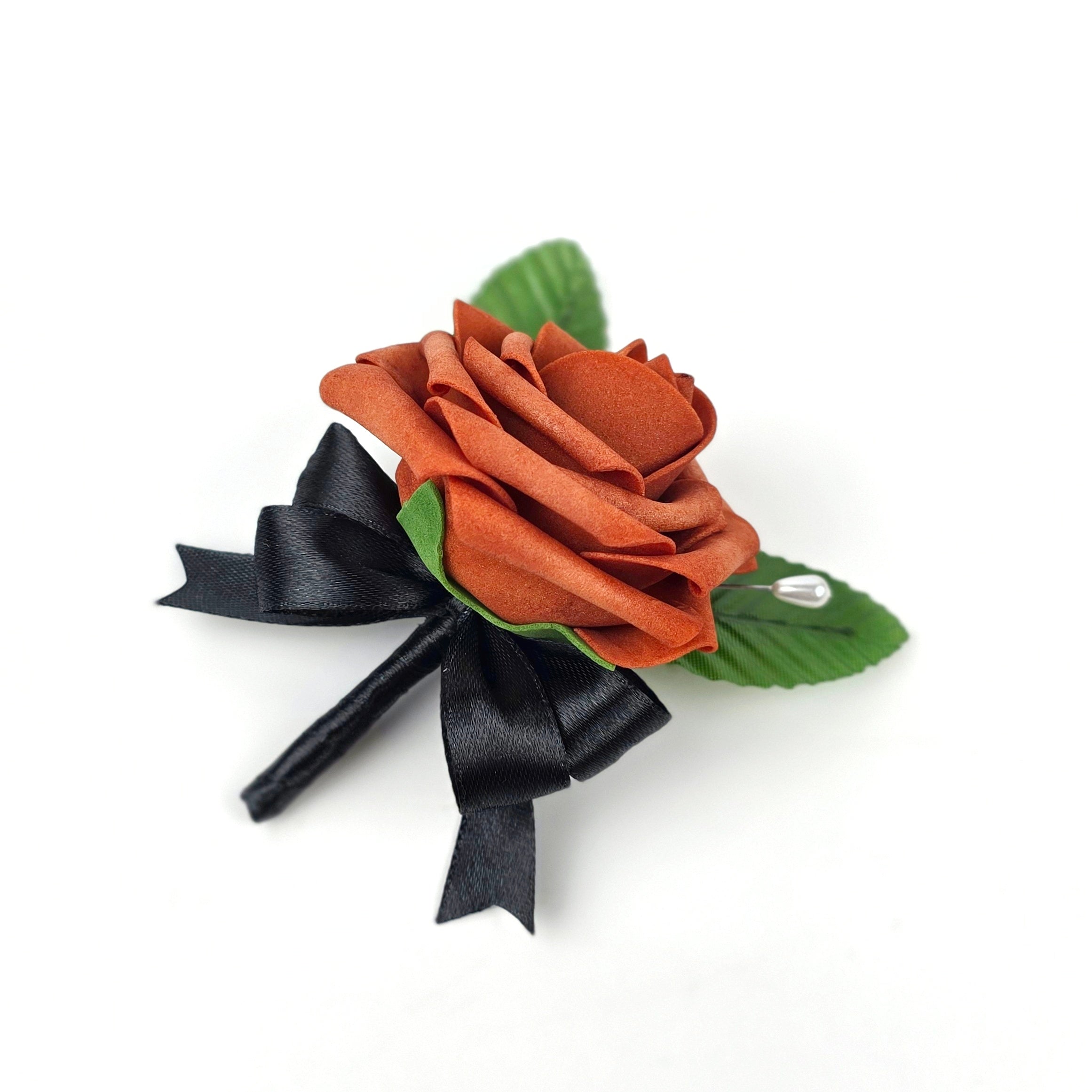 burnt orange and black boutonniere with 2 green leaves and pearl pin