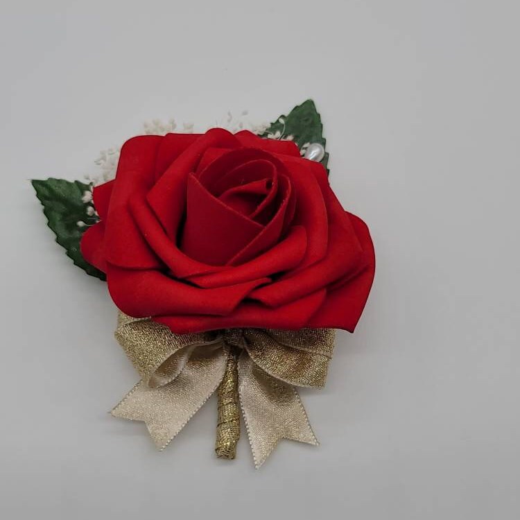 red rose boutonniere with gold ribbon. faux leaves and babies breath with pearl pin