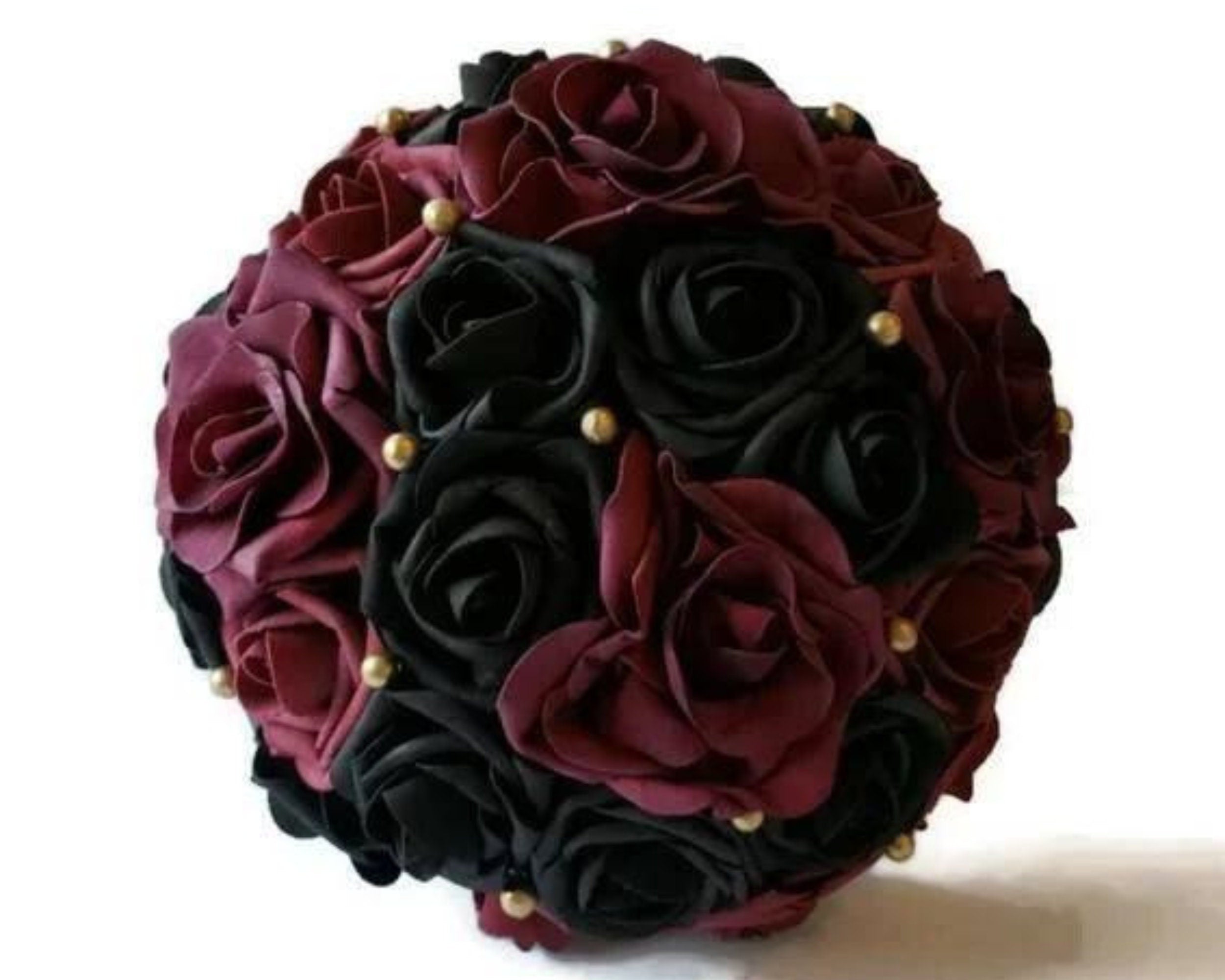 Burgundy and black bouquet with avalanche roses and gold balls scattered through out. handle is made up of gold ribbon.