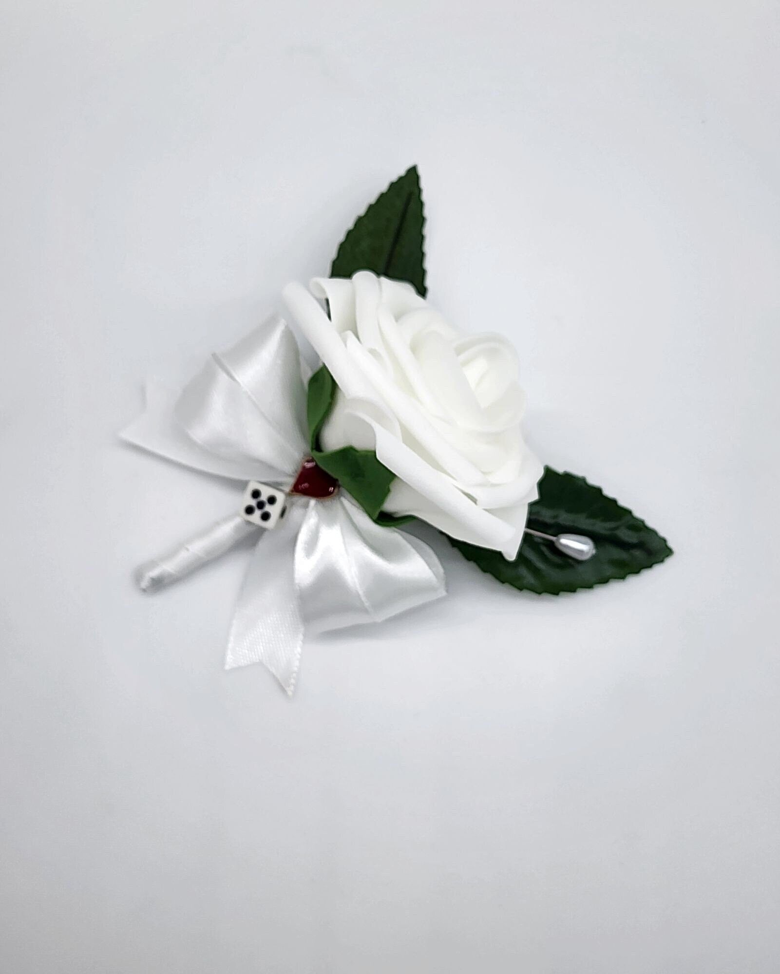 White Las Vegas Boutonniere with white ribbon. Card Suit and dice added to each.