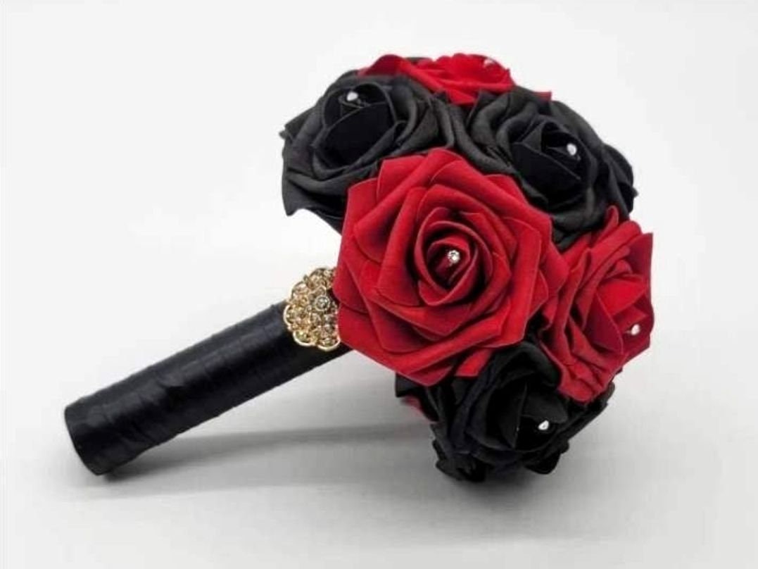 Red and black roses with satin black ribbon. Finished with a gold brooch. Rhinestones are on every rose. Great for wedding bouquets for brides, bridesmaids, toss bouquets. Also prom, homecoming, and Quinceanera's. Great for Halloween, gothic weddings