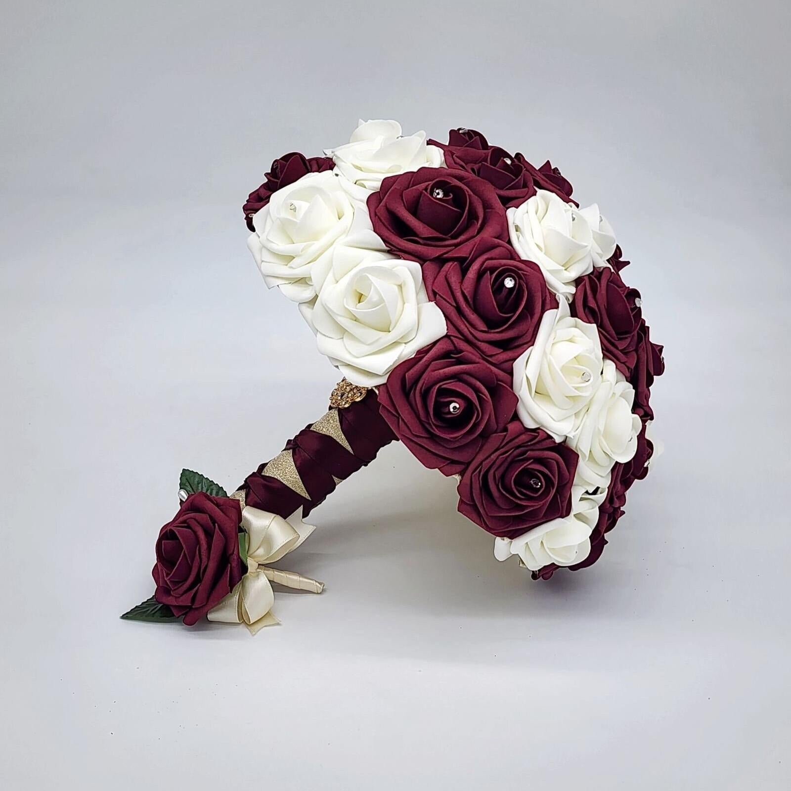 Burgundy and ivory wedding bouquet made with Real Touch Roses. Rhinestones are in the center of Roses. Handles is ivory and burgundy French twist and finished withgold brooch and gold bling wrap
