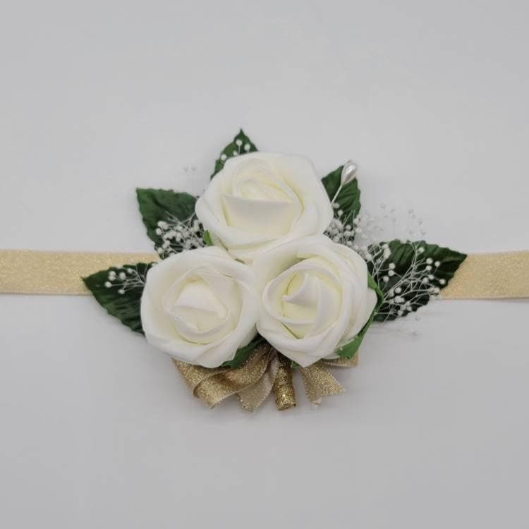 Ivory and gold wrist corsage with baby's breath