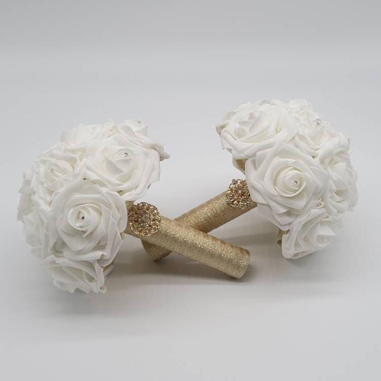 2 White bouquets with gold ribbon.
