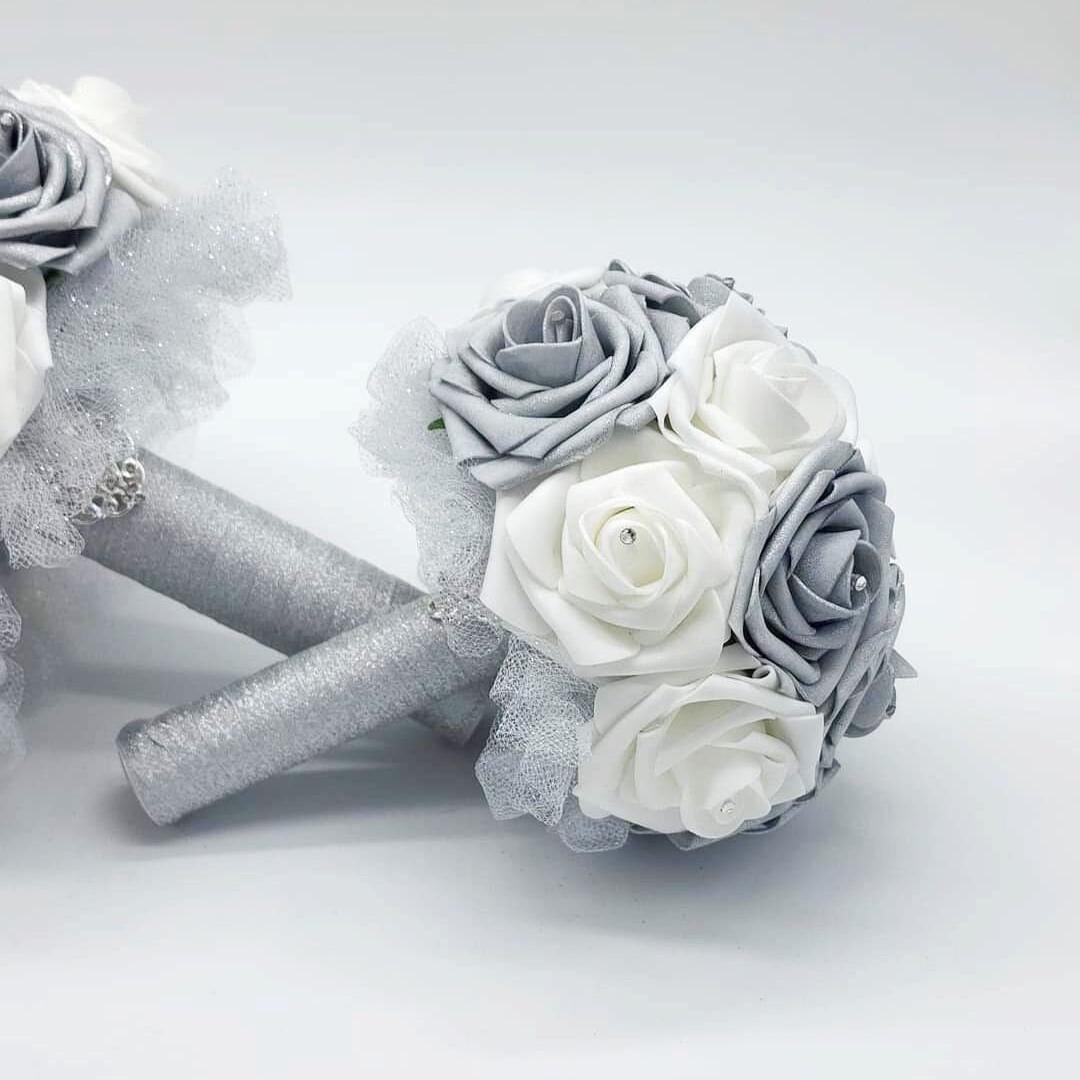 A bridal bouquet with white and silver roses, accented with silver glitter and tulle.