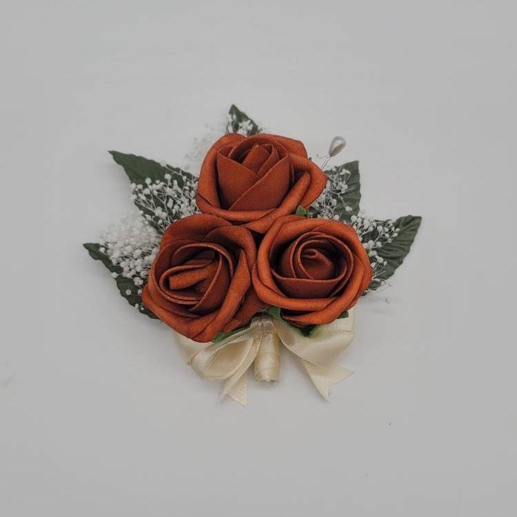 Burnt orange and ivory pin on corsage with baby's breath