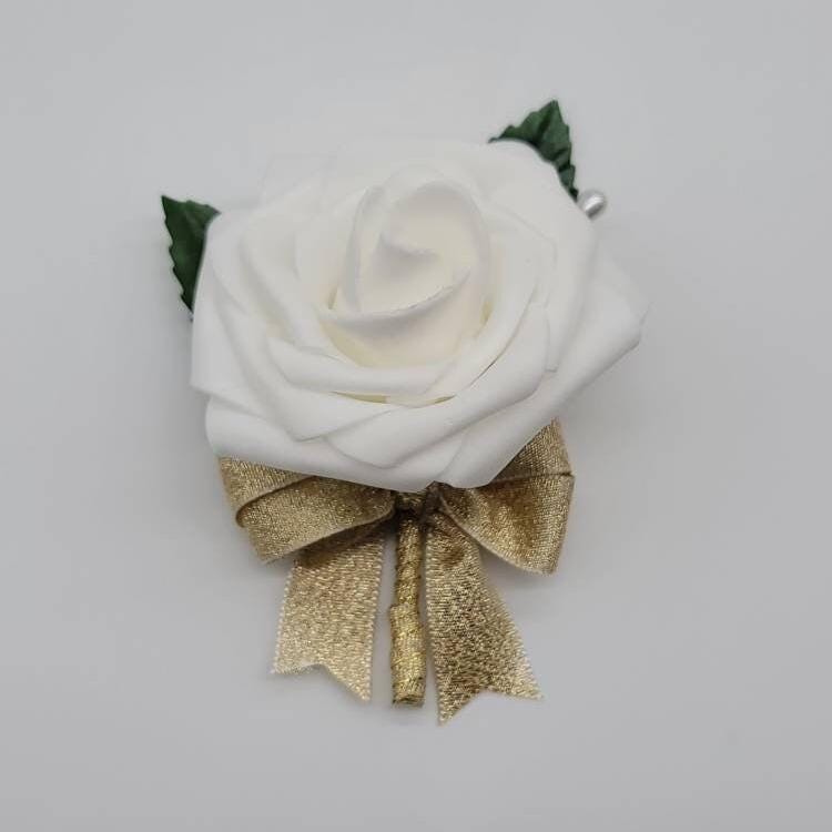 Ivory boutonniere with gold ribbon