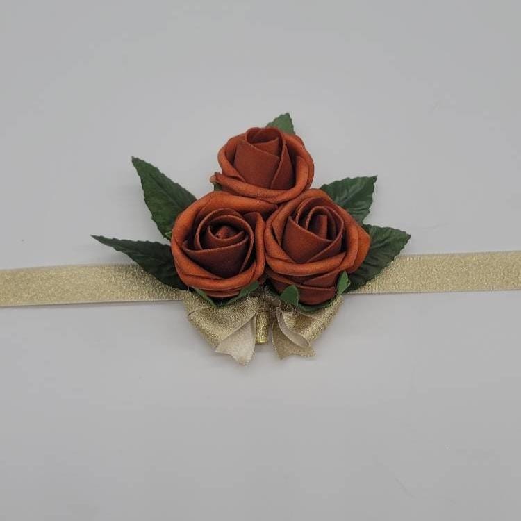burnt orange wrist corsage with gold ribbon