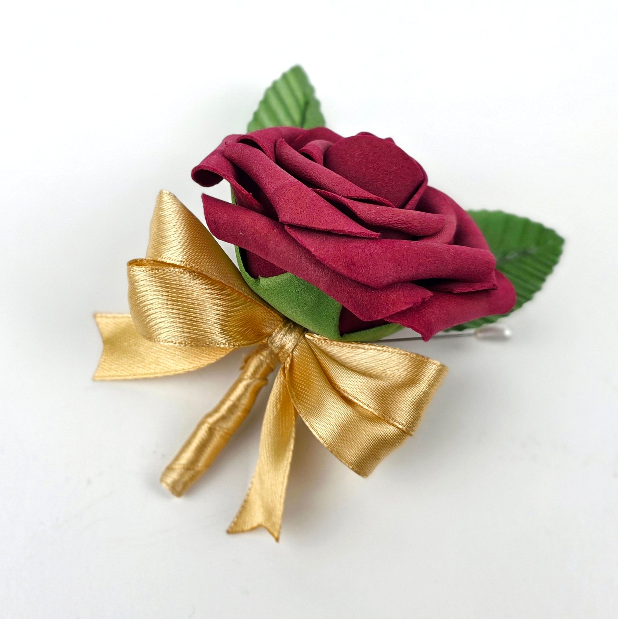 Burgundy boutonniere with gold ribbon and 2 green leaves
