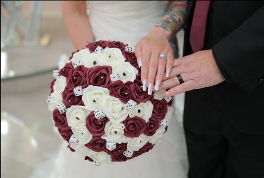 Burgundy and ivory las vegas bouquet with rhinestones, card suits, and dice scattered throughout.