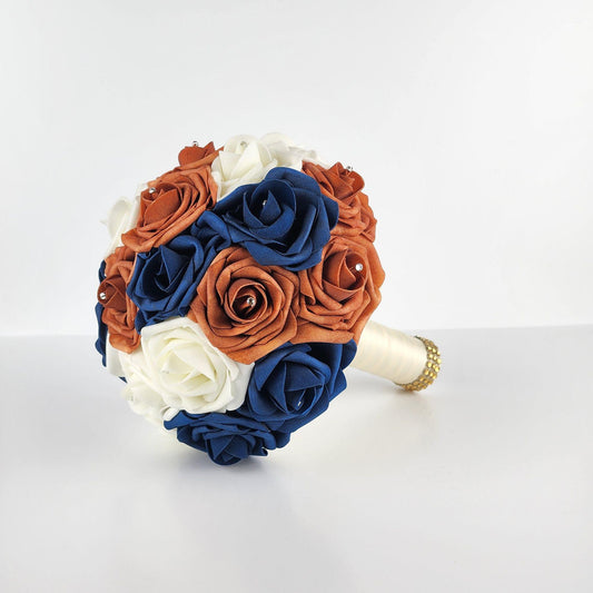 Burnt orange, navy, and ivory roses with rhinestones in every rose. handle is made up of ivory ribbon and finished with gold bling wrap.