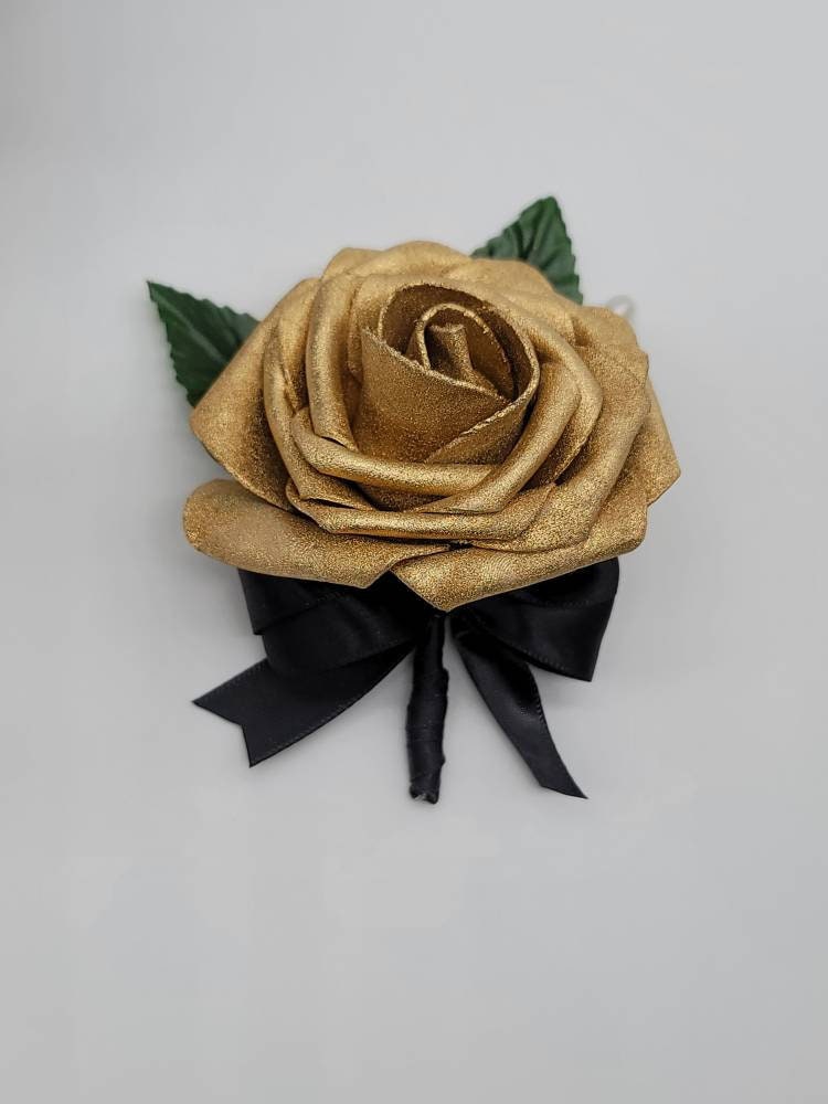 Gold boutonniere with black satin ribbon.