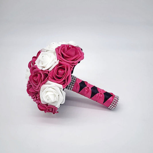 Hot pink and white bouquet with rhinestones on every rose. Handle is made out of hot pink and black satin ribbon and finished with silver bling wrap.