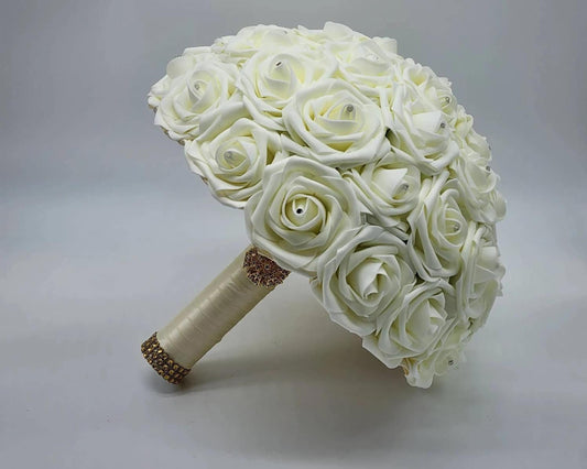 Ivory rose wedding bouquet with rhinestones on every rose. Ivory ribbon finished with gold brooch and bling wrap