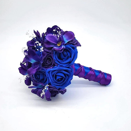 Purple and Royal Blue galaxy wedding bouquet with orchids and pearl spray on the flowers. handle is made up of royal blue and purple ribbon in a French twist style.