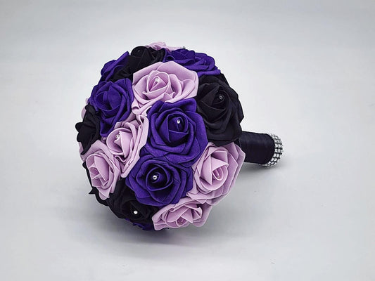 purple, lilac, and black real touch rose bouquet with satin black ribbon and finished with silver bling wrap. Rhinestones are placed on every rose.