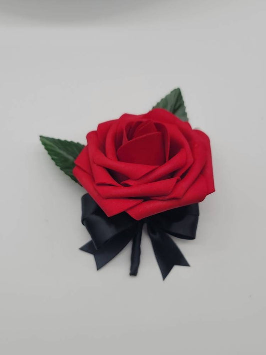 Red and Black Boutonniere with 2 faux leaves. Handle is made using satin black ribbon