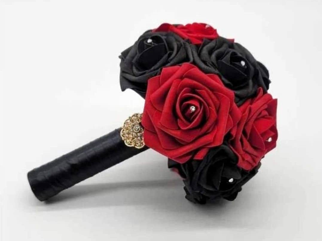 Red and black roses with satin black ribbon. Finished with a gold brooch. Rhinestones are on every rose. Great for wedding bouquets for brides, bridesmaids, toss bouquets. Also prom, homecoming, and Quinceanera&#39;s. Great for Halloween, gothic weddings