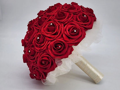 Red rose bouquet with rhinestones on every rose. handle is made up of ivory tulle and ribbon with a silver brooch