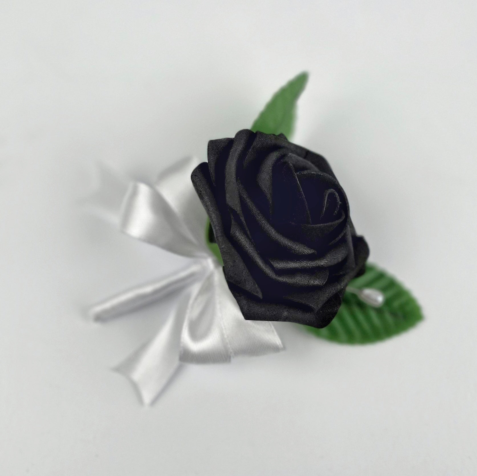 A black real touch rose with white satin ribbon.