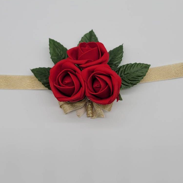 3 bud red rose wrist corsage. faux leaves and gold ribbon. its a tie on wrist corsage using gold ribbon.