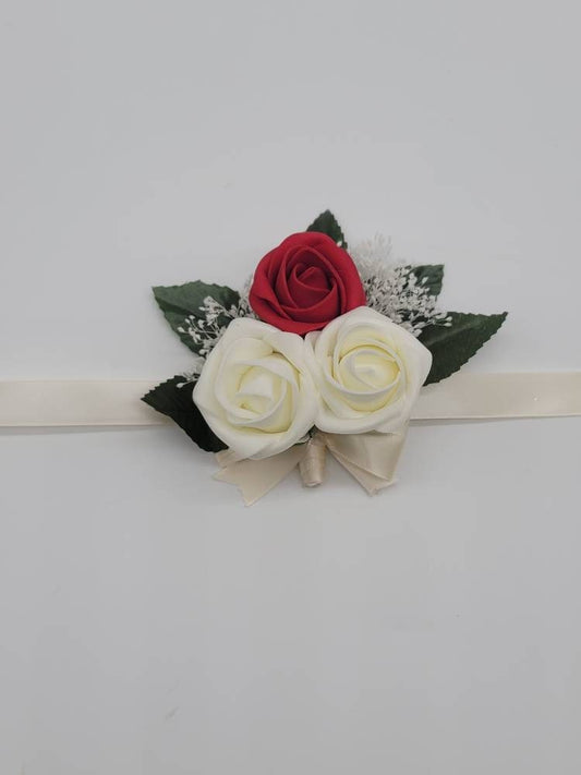 Red and ivory wrist corsage with baby breath. Roses are rose bud and made using real touch roses. Baby&#39;s breath and faux leaves.