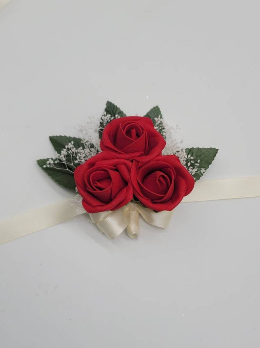 Red rose wrist corsage with ivory ribbon and baby breath.