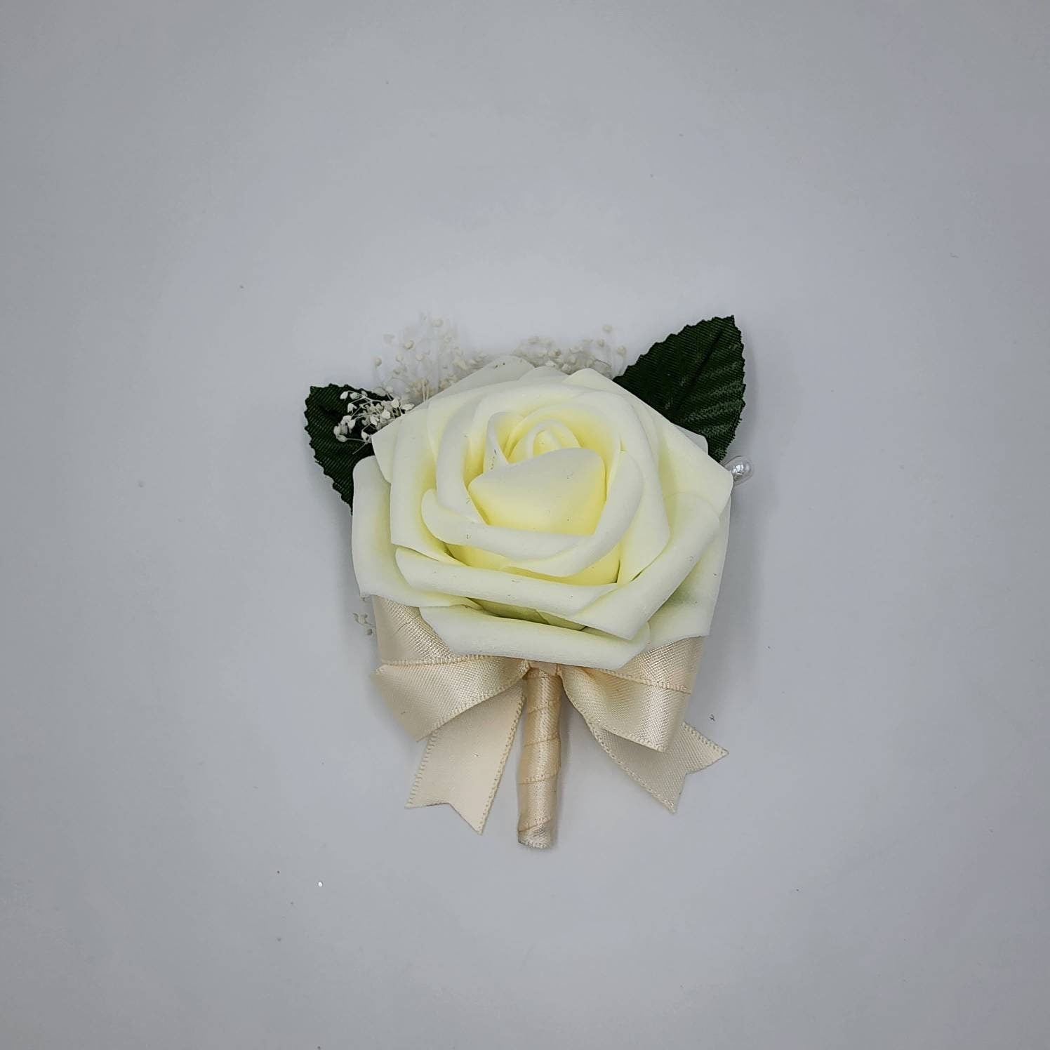 Ivory boutonniere with ivory ribbon and baby's breath