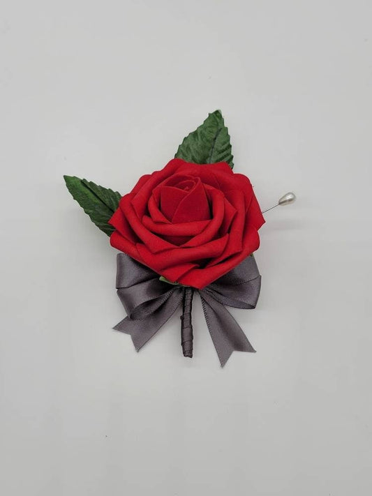 Red rose boutonniere with gray satin ribbon. Faux leaves and pearl pin