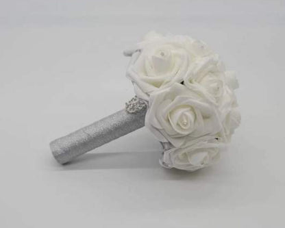 White rose wedding bouquet with rhinestones on every rose. Handle is made up of silver ribbon and finished with a silver brooch.