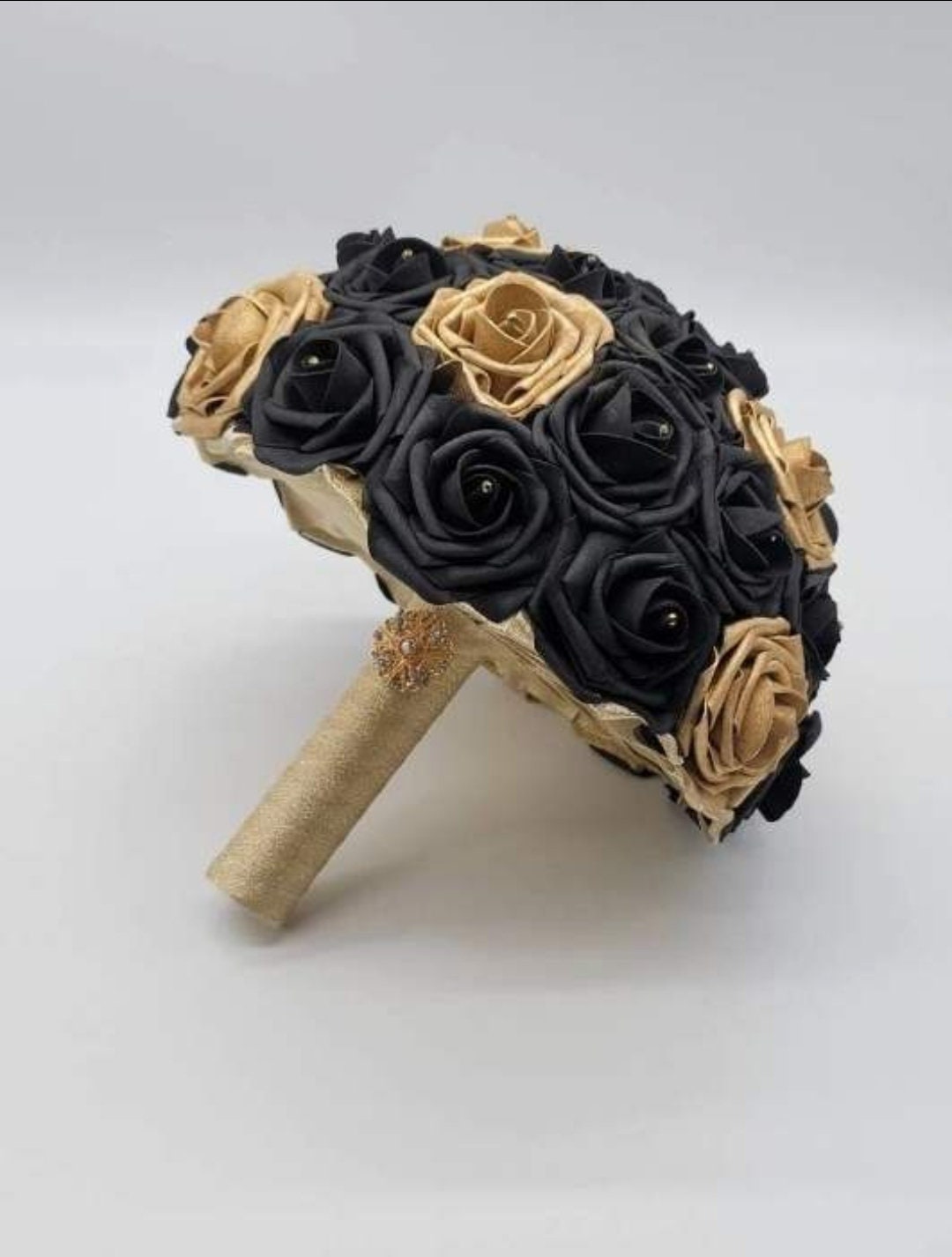 Black and gold bridal bouquet made with real touch roses. Rhienstones on every flower. gold brooch on handle.