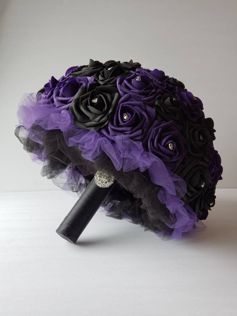 Black and purple roses with skulls on every rose. Handle is made up of purple and black tulle, black satin ribbon and finished with silver brooch.