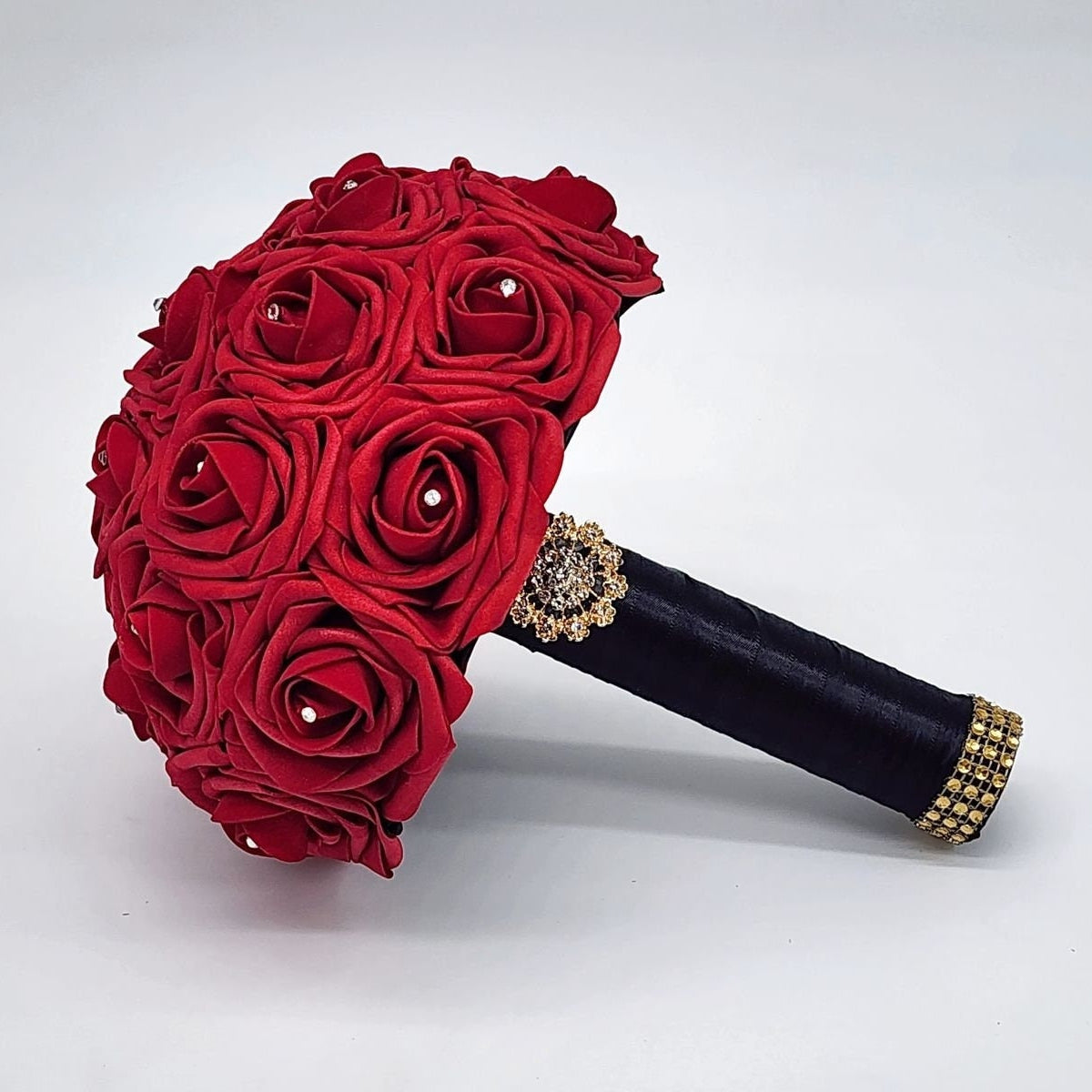 Red Real Touch Roses Wedding Bouquet with Black Satin Ribbon handle. Handle is finished with a gold brooch and gold bling wrap. Rhinestones are on every rose. Great for brides, bridesmaids, prom, homecoming, and Quinceanera.