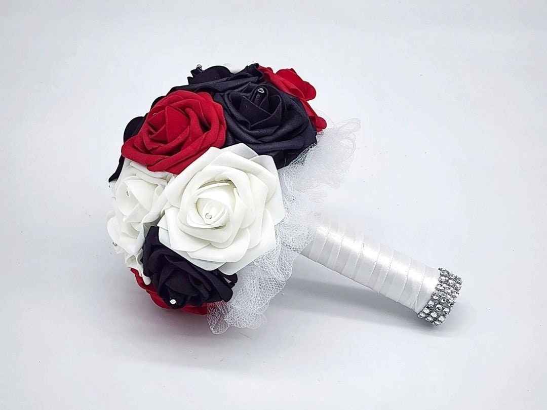 red, black, and white roses with rhinestones on every rose. Handle is made up of white tulle and satin ribbon with silver bling wrap.