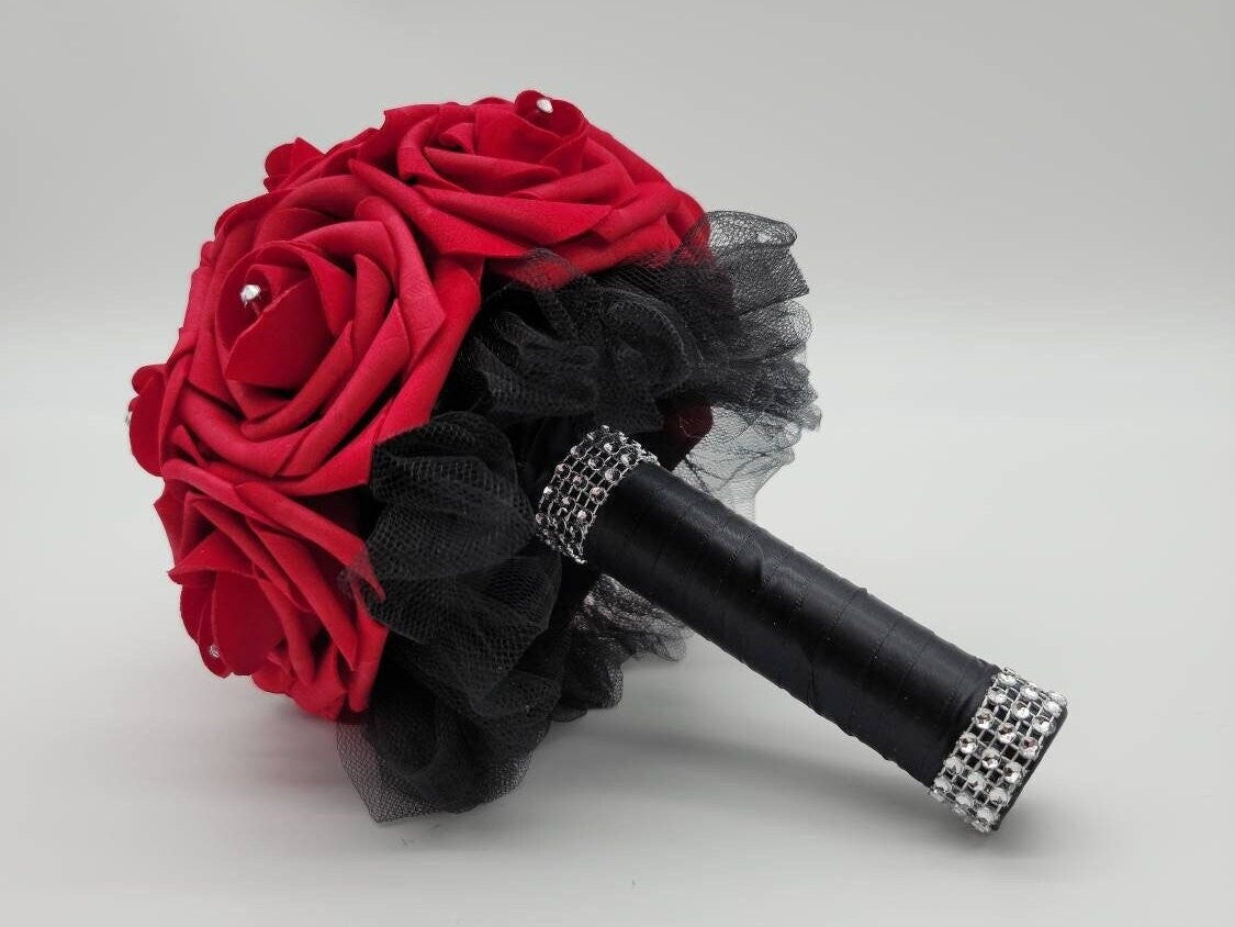 6 inch toss bouquet with red roses. Handle is made using black satin ribbon and finished with silver bling wrap. rhinestones are in the center of Evey rose.