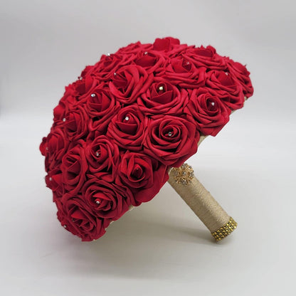 Red wedding bouquet made with real touch roses. Handle is made using gold ribbon and finished with a gold brooch. Rhinestones are on every rose.