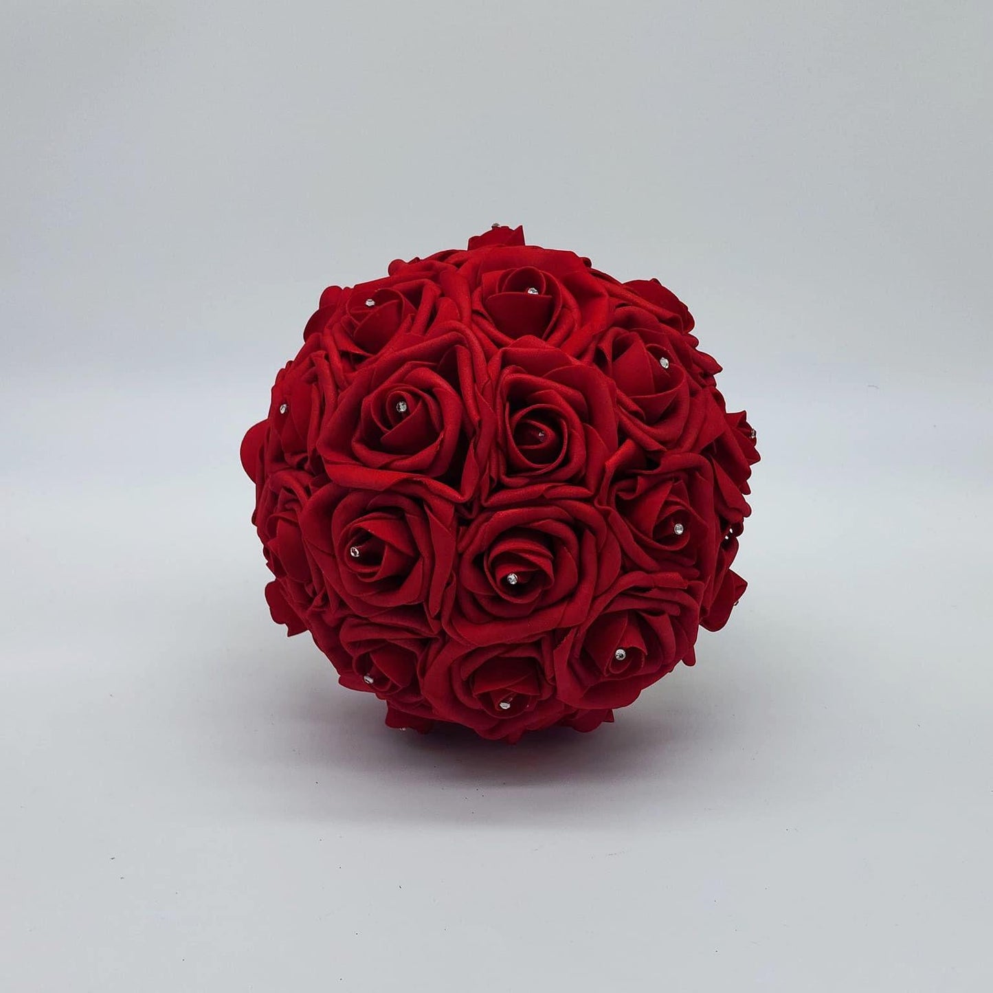 Red wedding bouquet made with real touch roses. Handle is made using gold ribbon and finished with a gold brooch. Rhinestones are on every rose.