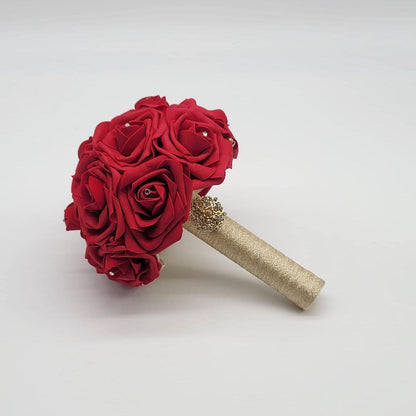 Red wedding bouquet made with real touch roses. Handle is made using gold ribbon and finished with a gold brooch. Rhinestones are on every rose.