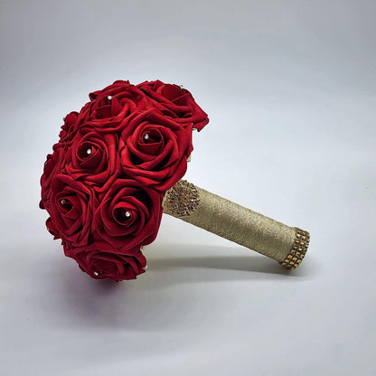 Red wedding bouquet made with real touch roses. Handle is made using gold ribbon and finished with a gold brooch. Rhinestones are on every rose.