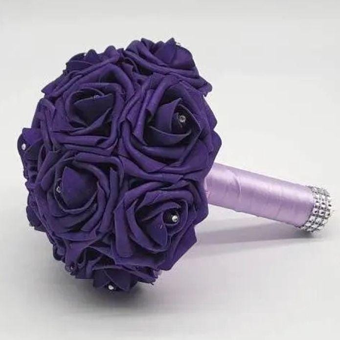 A purple Real Touch rose bouquet with a lavender ribbon and rhinestone accents.