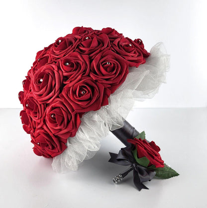 Red roses with rhinestones on every rose. Handle is made up of gray tulle and ribbon and finished with silver bling wrap