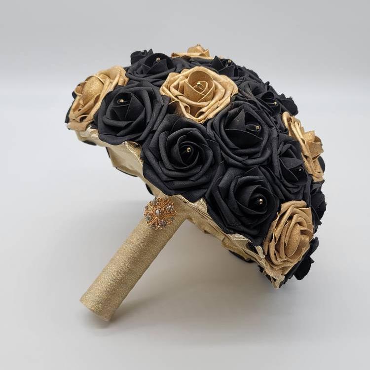 Black and gold bouquet with rhinestones on every rose. handle is made up of gold ribbon and finished with gold brooch.
