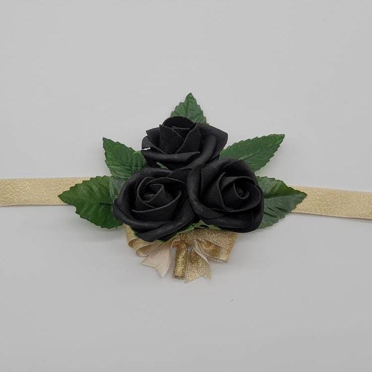 black corsage with gold ribbon