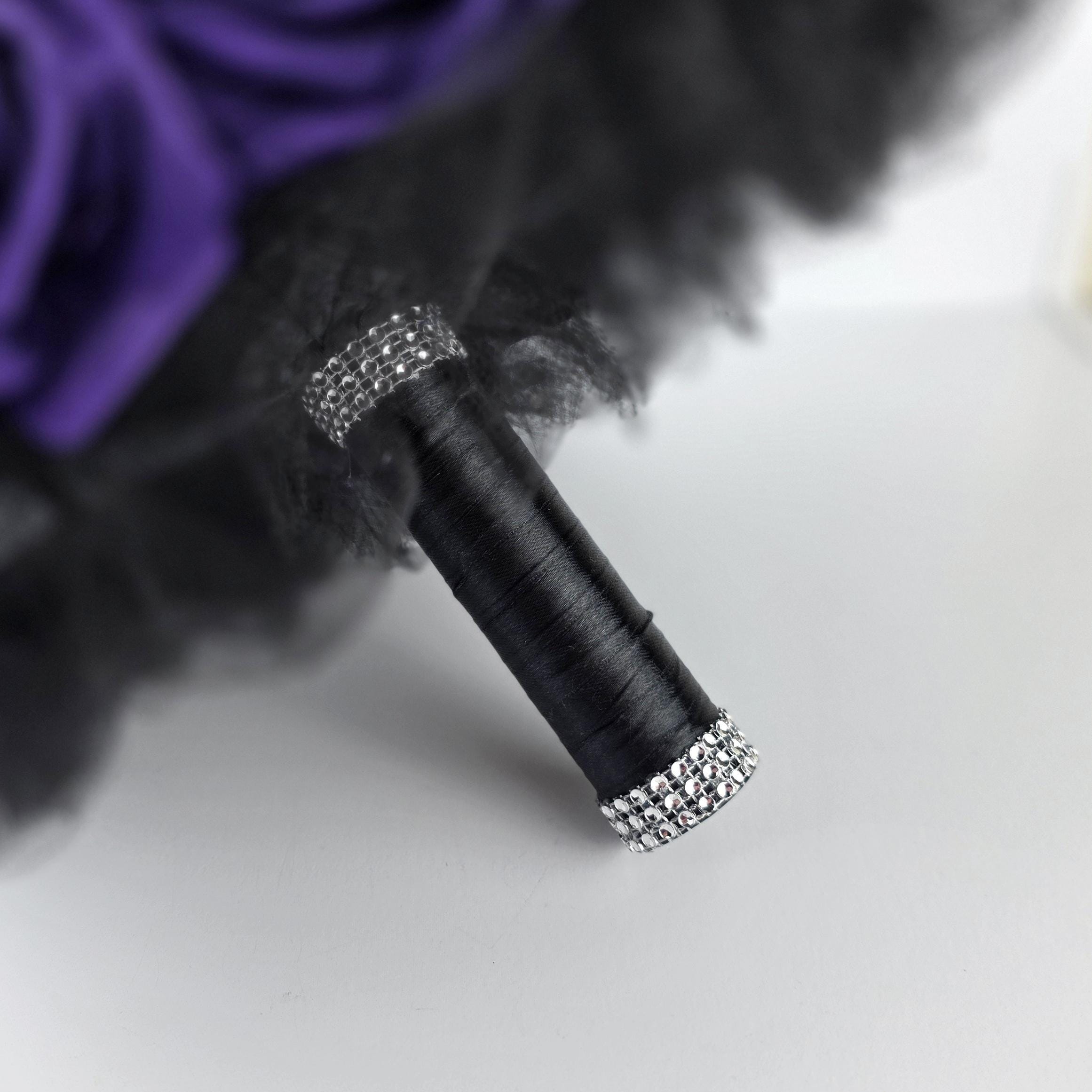 Handle of a bouquet wrapped in black satin ribbon and finished with silver bling wrap.