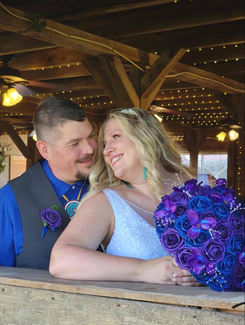 Couple sit happily with their 13 inch galaxy bridal bouquet