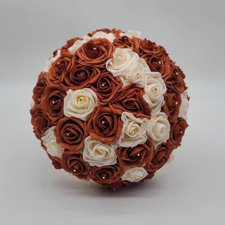 Burnt orange and cream real touch roses with rhinestones in each rose.