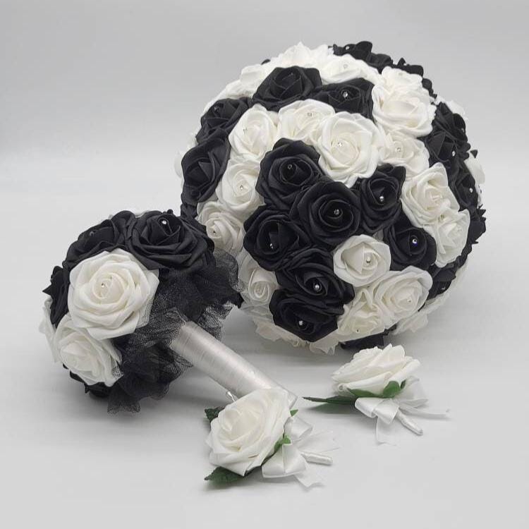 A bridal bouquet set featuring a large round bouquet and a smaller bouquet, both composed of black and white roses. A matching boutonniere is also included. The bouquets have a classic, elegant design, perfect for a wedding.