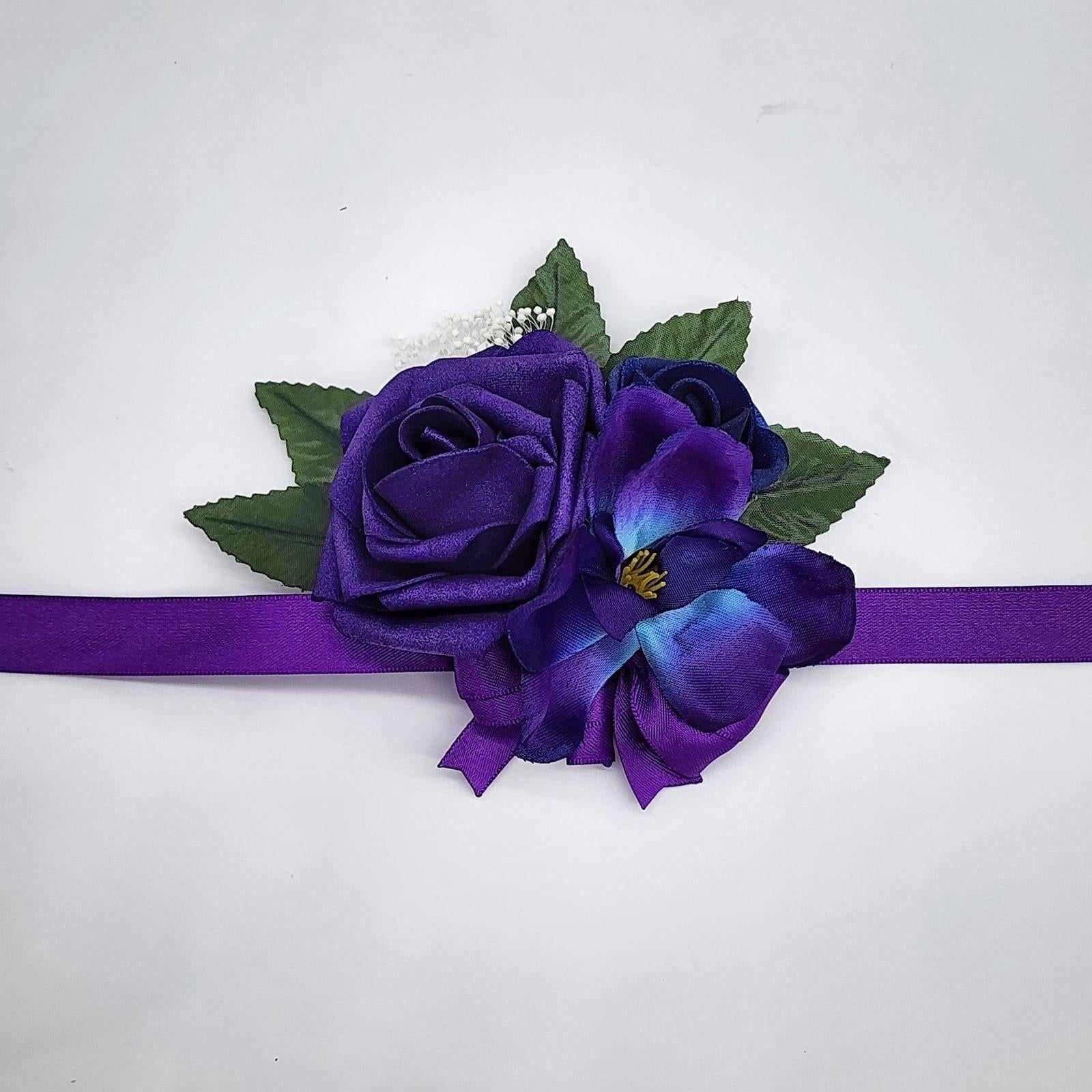 Galaxy wrist corsage with purple and royal blue real touch roses. A galaxy orchid and purple ribbon.