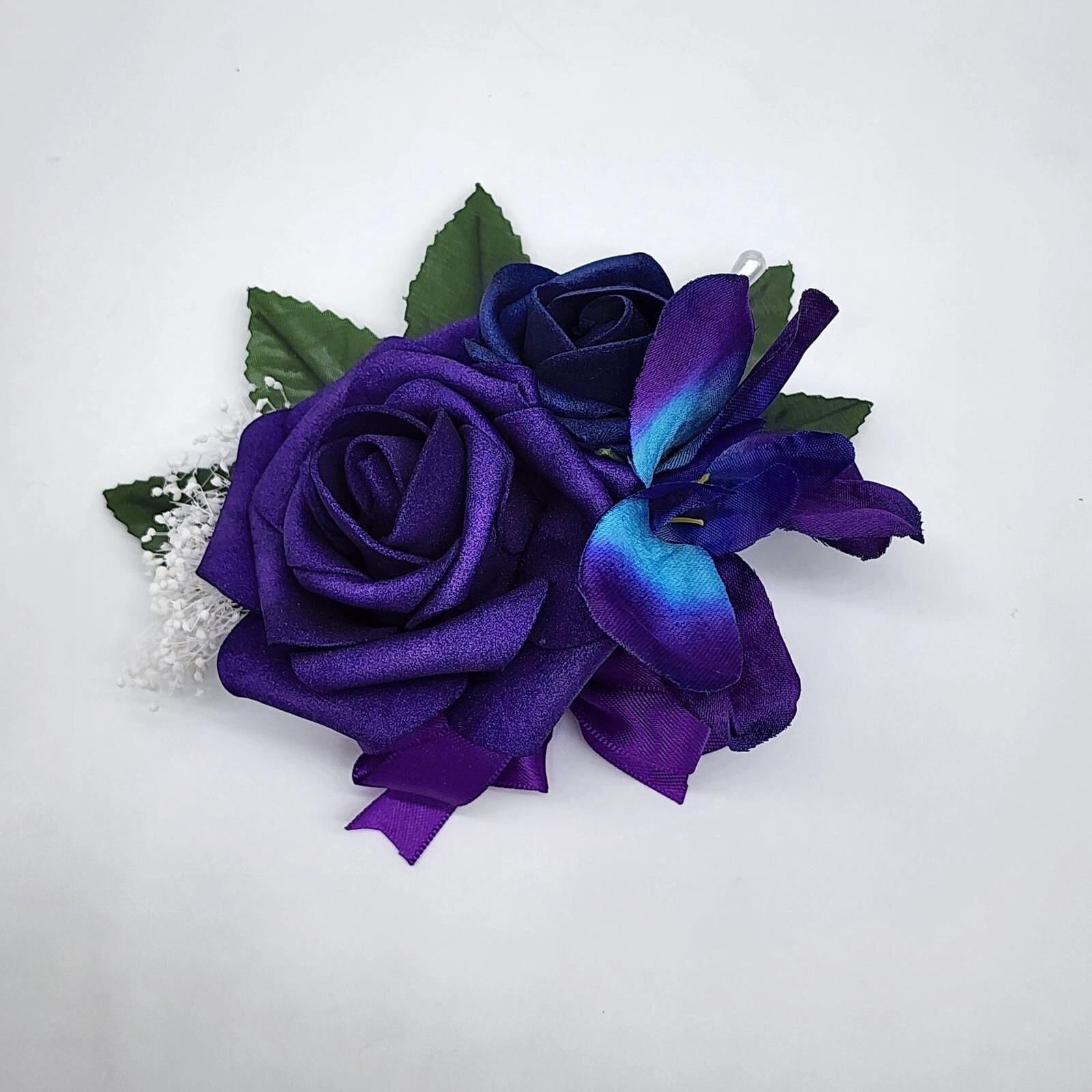 Galaxy pin on corsage with purple and royal blue real touch roses. A galaxy orchid and purple ribbon.