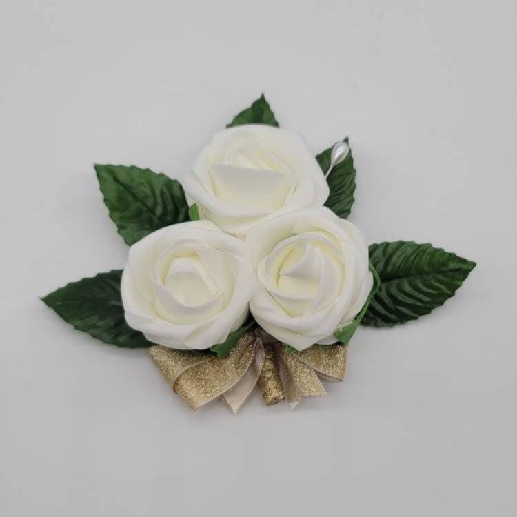 Ivory pin on corsage with gold ribbon. 5 faux leaves
